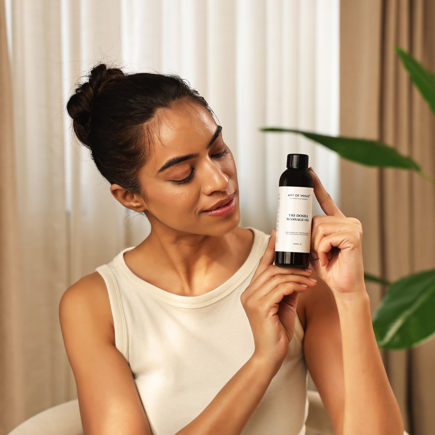 Art of Vedas Tri-Dosha Massage Oil - Woman Holding Ayurvedic Abhyanga Oil Bottle for Balancing All Three Doshas and Full Body Massage