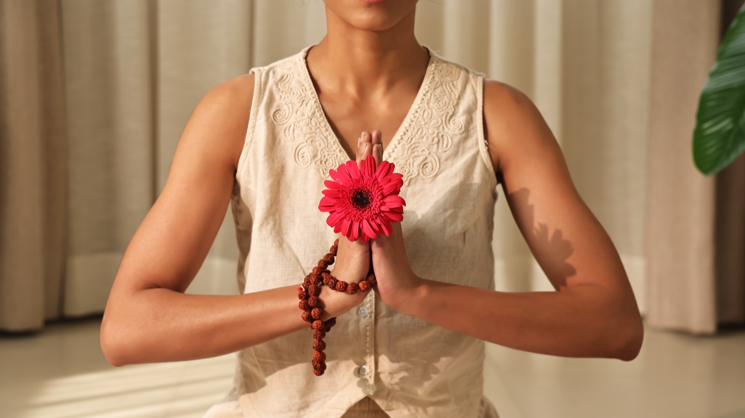Kvinna med en blomma i en Namaskar-gest för Art of Vedas